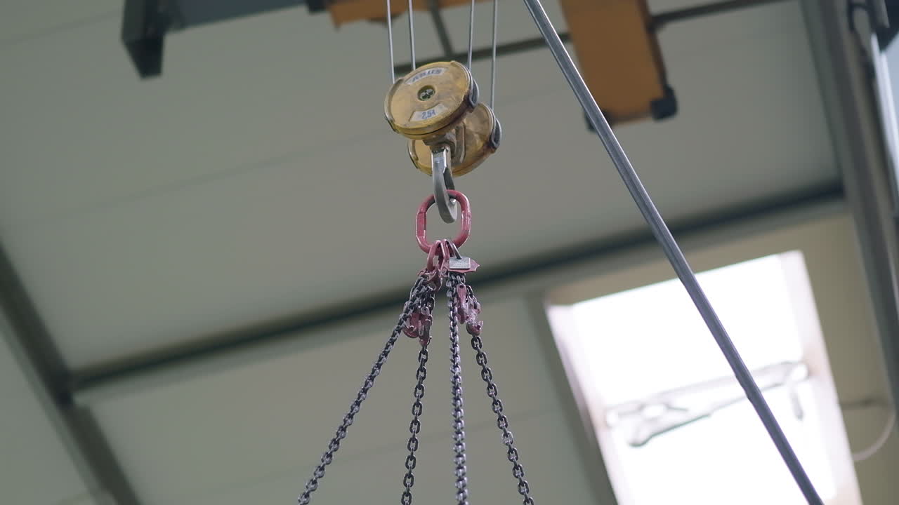 incline hacia abajo tiro medio, grúa puente de fábrica amarilla que transporta una enorme carga de molde de acero inoxidable en el exterior y plástico en el interior