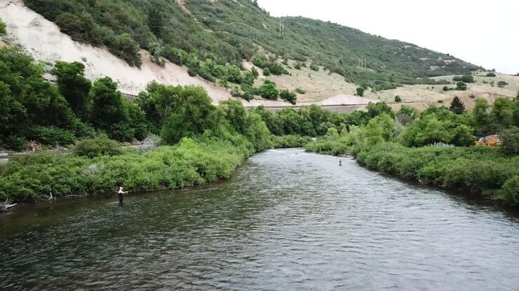 Ripresa drone in avvicinamento a un uomo che pesca a mosca nel fiume Provo nelle Montagne dello Utah