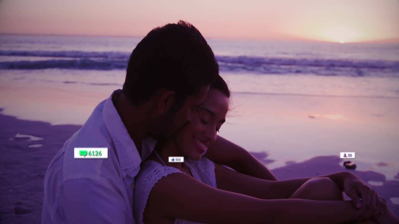 Couple sitting on sunset beach after pause seeing rising social media tech icons driving engagement