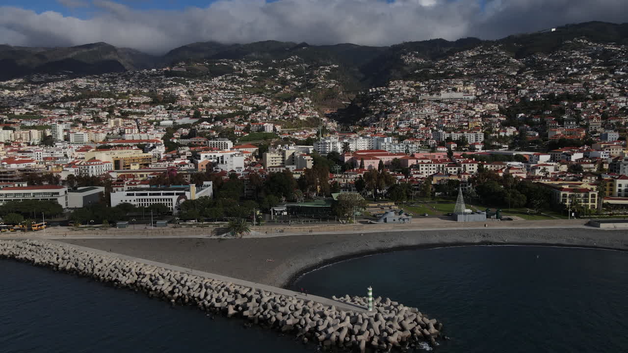 toma aérea sobre la playa del puerto de funchal y sobre las casas y edificios cerca de la costa