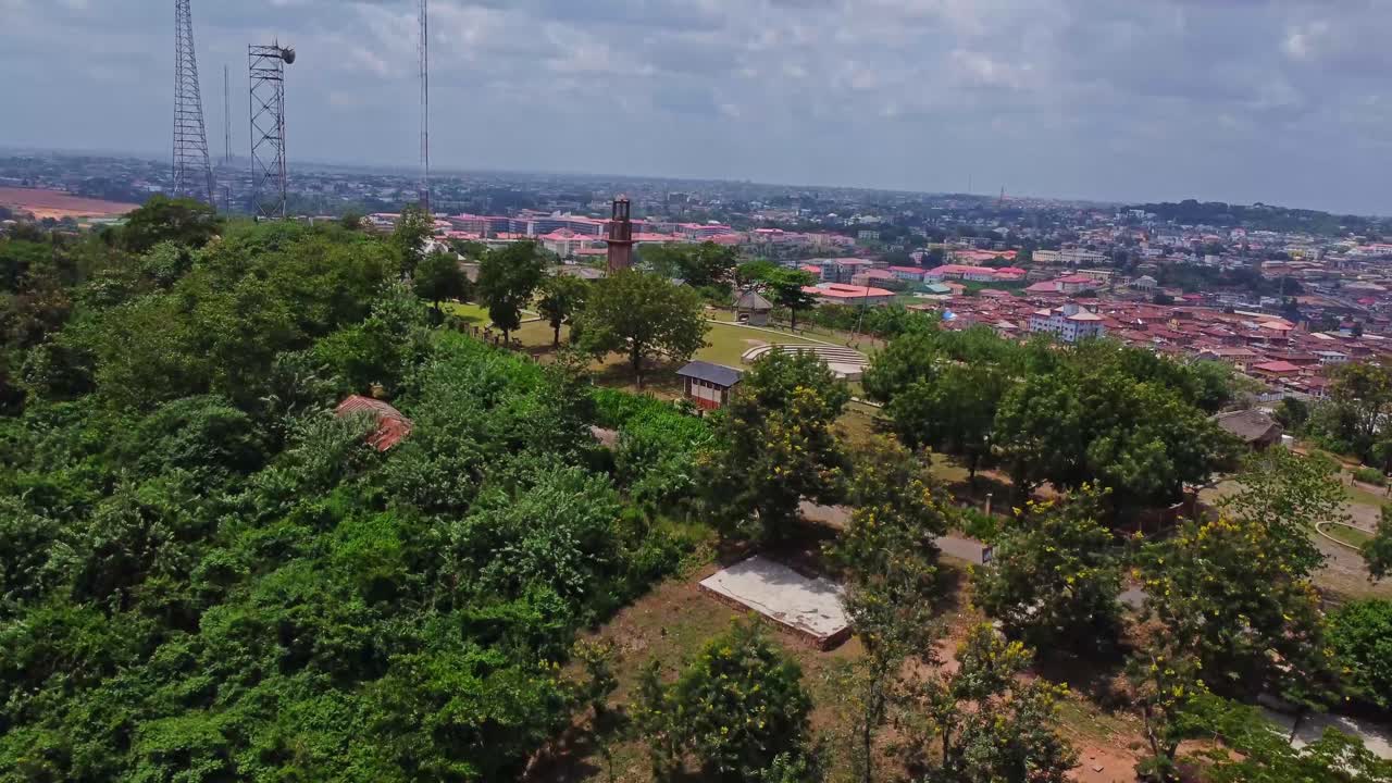 Beautiful jib up of Oke Are hill with the monumental Bowers Tower on top of the hill in Ibadan, Nigeria. The city can be seen in the background