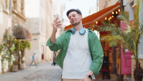 Blogger-Hombre-Feliz-Tomando-Selfie-En-Un-Teléfono-Inteligente-Comunicando-Videollamadas-En-Línea-Con-Suscriptores