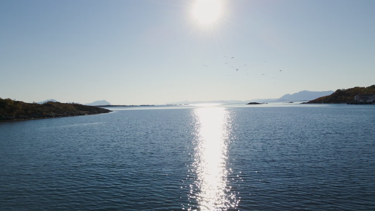 여름에는 노르웨이 센자 섬의 잔잔한 반짝이는 파도 위를 날고 있습니다.