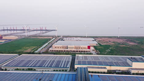 aerial shot approaching newly built distribution warehouse with windmills in the background