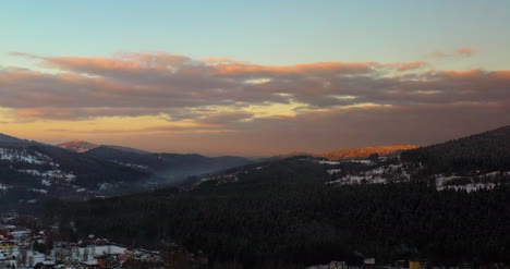 Aerial-View-Of-Mountains-And-Forest-Covered-With-Snow-At-Sunset-In-Winter-8