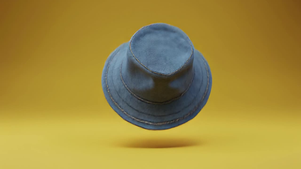 Blue Denim Bucket Hat Rotating on a Yellow Background