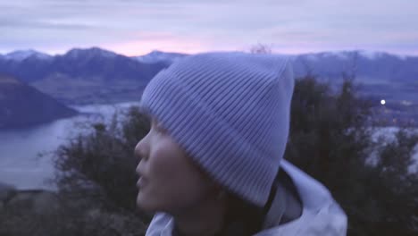 asian woman hiker across lake wanaka overlooking roys peak in new zealand