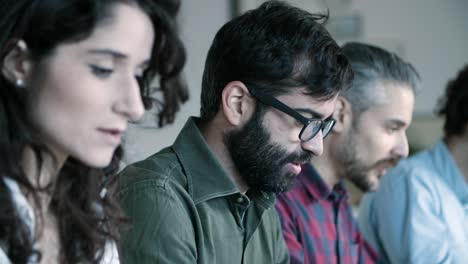 vista lateral de un desarrollador alegre con gafas trabajando con una computadora portátil