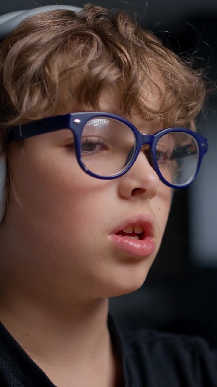 Ragazzo concentrato che indossa cuffie e occhiali blu
