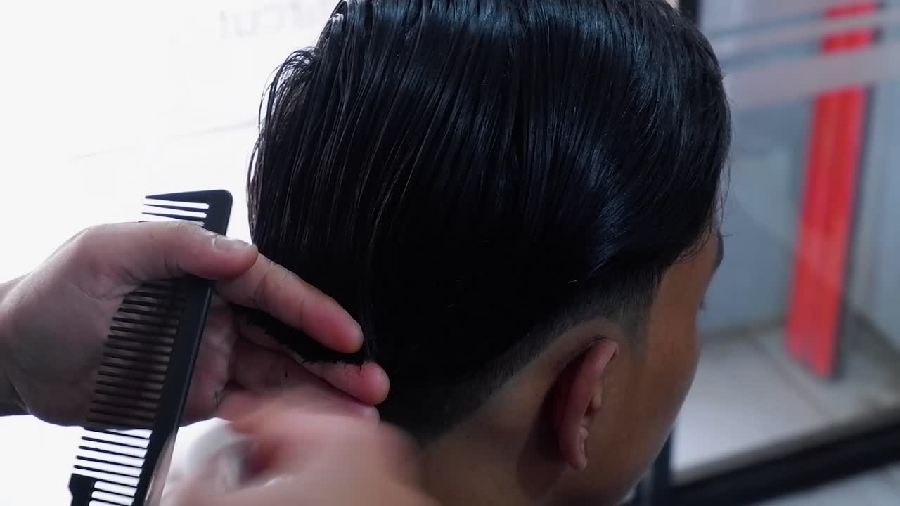 a hairdresser makes a mens haircut in a barbershop