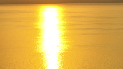 three friends paddleboard on the lake during sunset