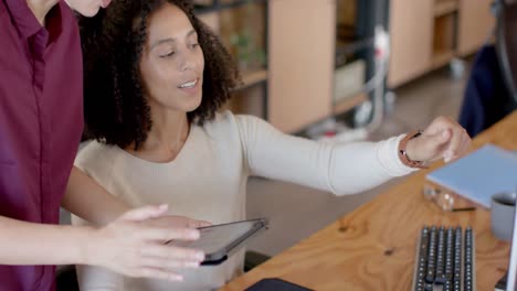 happy diverse casual businesswomen using tablet and talking in office in slow motion