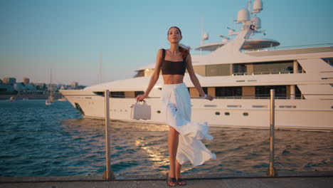 stylish woman posing on a yacht pier at sunset