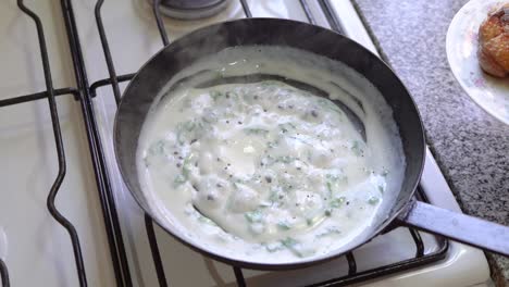 Succulent-chicken-thighs-being-cooked-in-pan-of-basil-cream