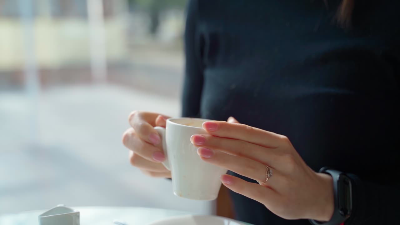 Woman drinking cup of coffee. Woman sitting at table in cafe