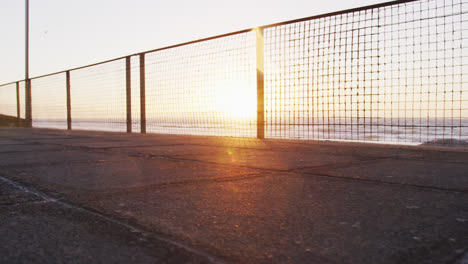 Low-section-of-african-american-man-exercising-outdoors,-running-by-seaside-at-sunset