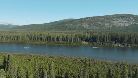 Beautiful-wide-angle-aerial-shot-of-motorized-canoe's-heading-up-river-in-the-wilderness-of-Newfoundland-and-Labrador,-Canada