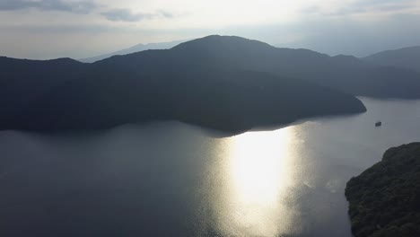 aerial view of sun reflections over lake ashi with ship panoroma