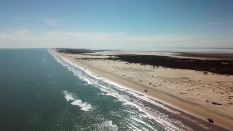 Aerial-drone-view-as-elevation-decreases-beach-at-low-tide-on-a-gulf-coast-barrier-island-on-a-sunny-afternoon---South-Padre-Island,-Texas
