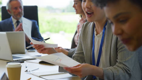 multi-cultural business team meeting and collaborating around table in modern office building