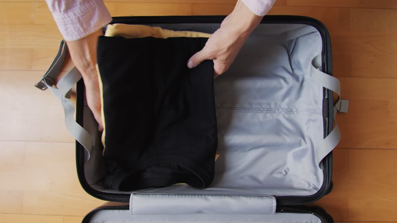 Tourism and travelling concept. Handsome business man going on holiday, packing his suitcase, checking luggage, sitting on bed and looking at packed things