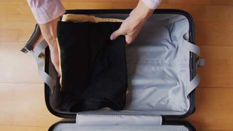 tourism and travelling concept. handsome business man going on holiday, packing his suitcase, checking luggage, sitting on bed and looking at packed things