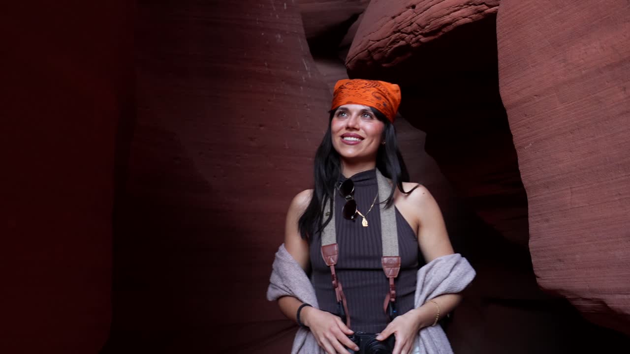 Happy Woman Exploring a Beautiful Slot Canyon with Camera