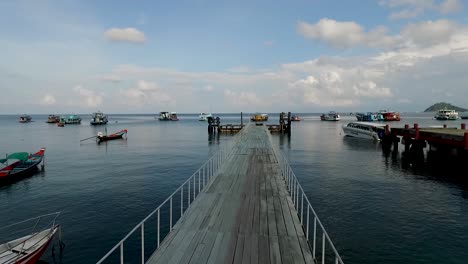 empty pier boats walking bridge drone pan right koh tao thailand