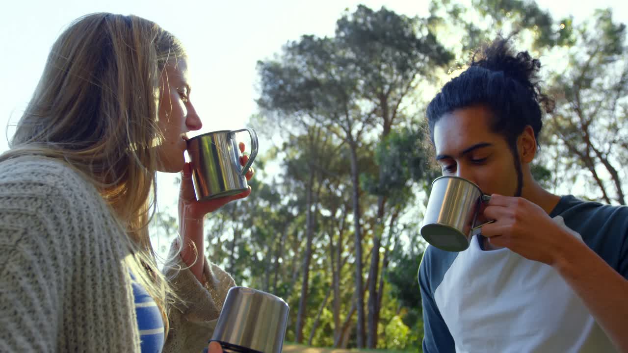 una joven pareja tomando café en el bosque 4k