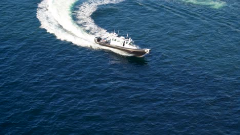 police boat makes a turn in the harbor after escorting a cruise ship away from port