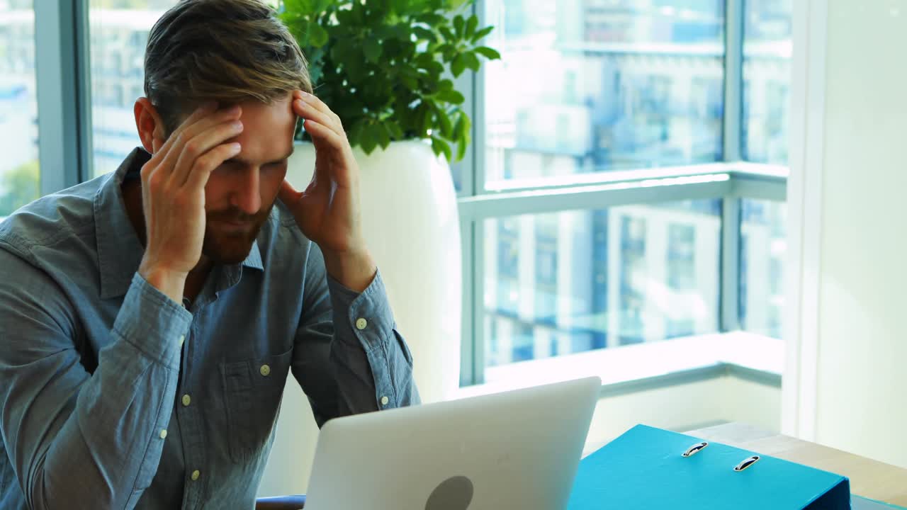 dirigente maschile che lavora sul portatile in ufficio