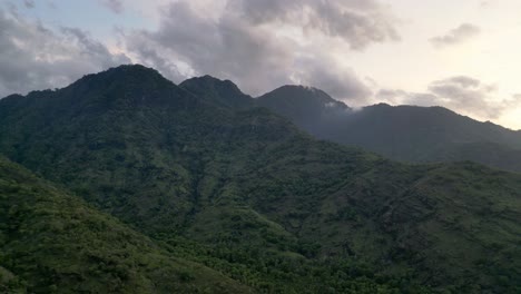 drone flying over mountains during sunset covered with green vegetation