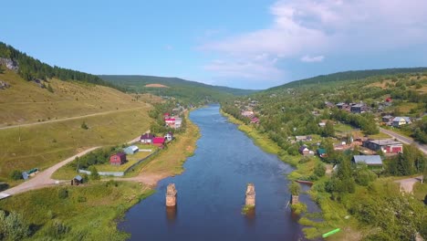 luftansicht eines dorfes an einem fluss in einem gebirgsgebiet