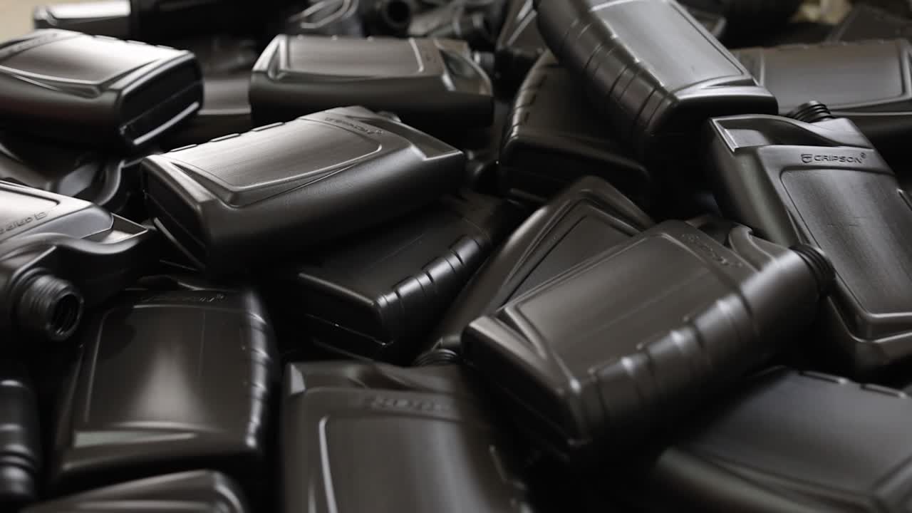 Pile of Black Plastic Oil Bottles