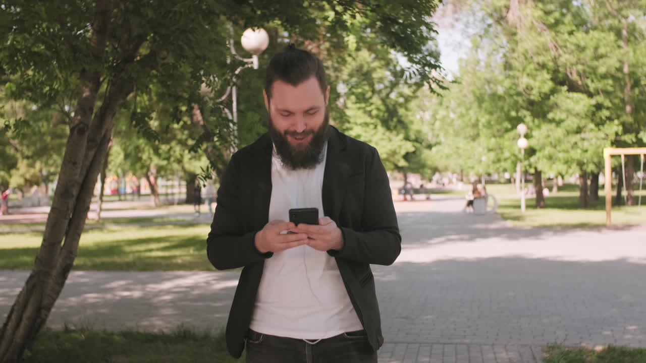 Man Walking Through Park and Chatting on Video Call
