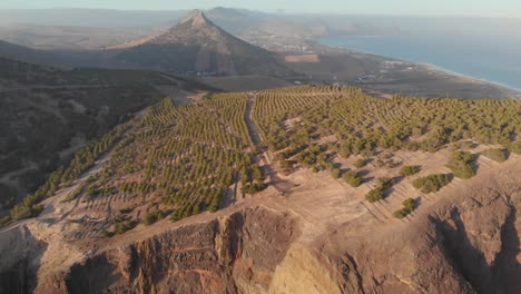 Aerial-ascending-shot-epic-landscape-crop-mountain-fields,-Porto-Santo-island