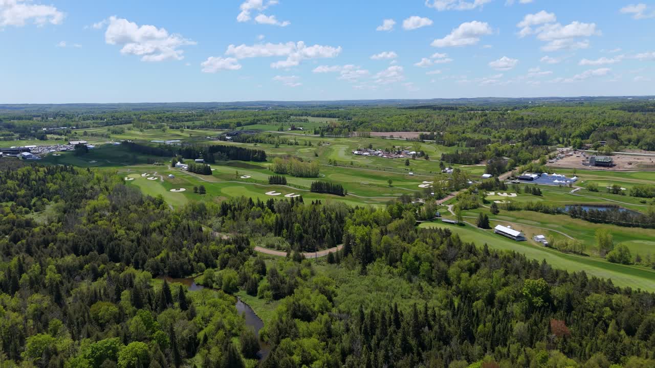 A wide aerial view of the TPC Toronto at Osprey Valley during the PGA RBC Canadian Open. The drone captures the championship course set up with tents and infrastructure for the event