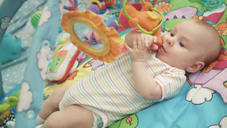 infant baby playing on colorful mat