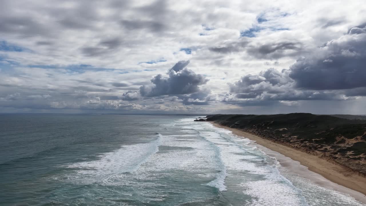 Drone captures dramatic coastline, rolling waves, and moody clouds at Portsea Beach, Victoria, Australia