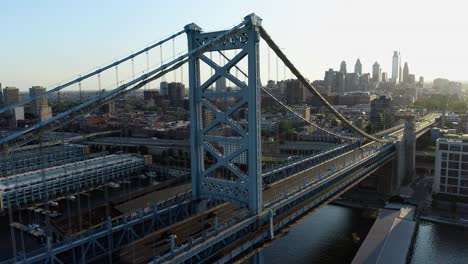 aerial footage of the benjamin franklin bridge at sunset with the delaware river and the philadelphia skyline in background