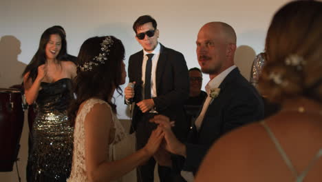 clip of an elegant party where women in formal dresses enjoy live music. a band can be seen livening up the event.