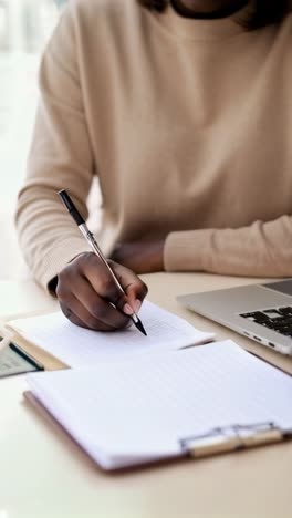 a person is writing in a notebook with a pen