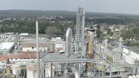 aerial circling of tall drt industrial distillation tower and processing equipment at factory complex, veille-saint-girons, france