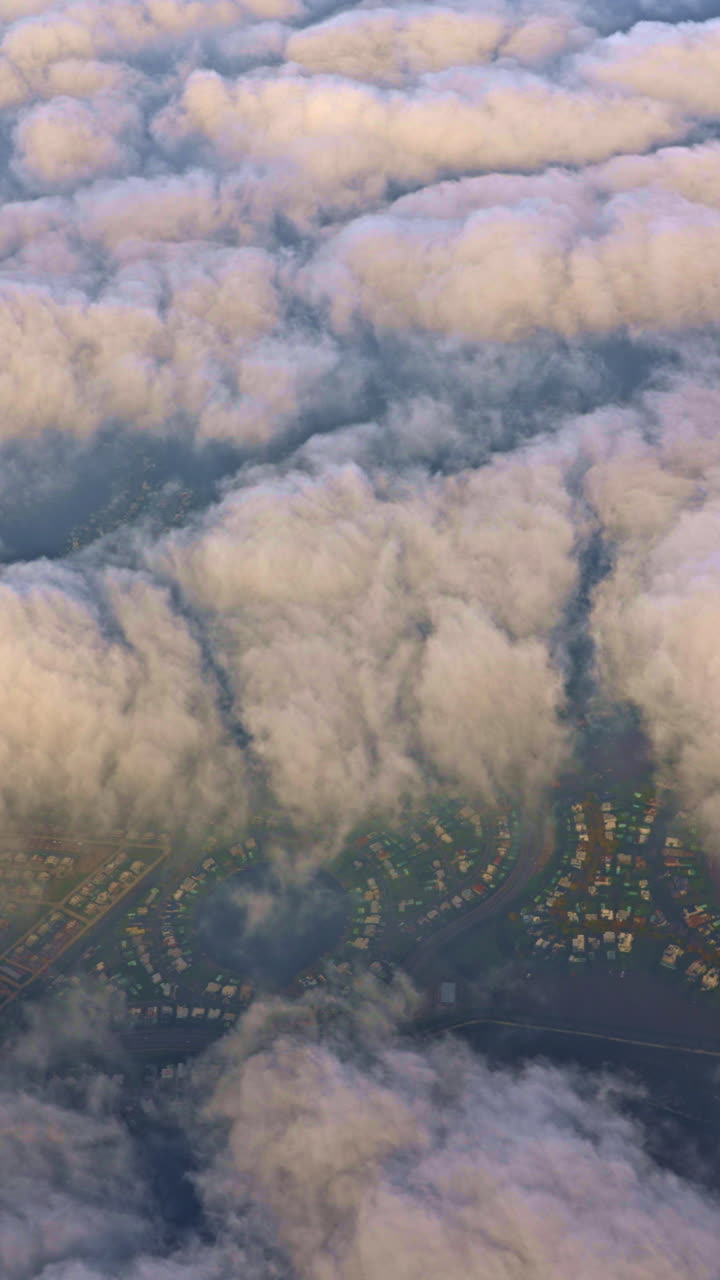 Vista aerea di una zona residenziale che si intravede tra le nuvole mattutine