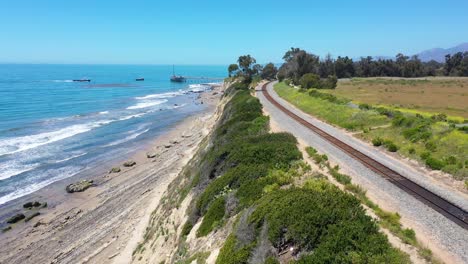 Antena-Sobre-Las-Vías-Del-Tren-Por-Encima-De-La-Costa-Del-Pacífico-Cerca-De-Carpinteria-Bluffs-Santa-Barbara-California