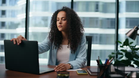 Depressed-businesswoman-opening-laptop-starting-work-in-company-office-close-up.