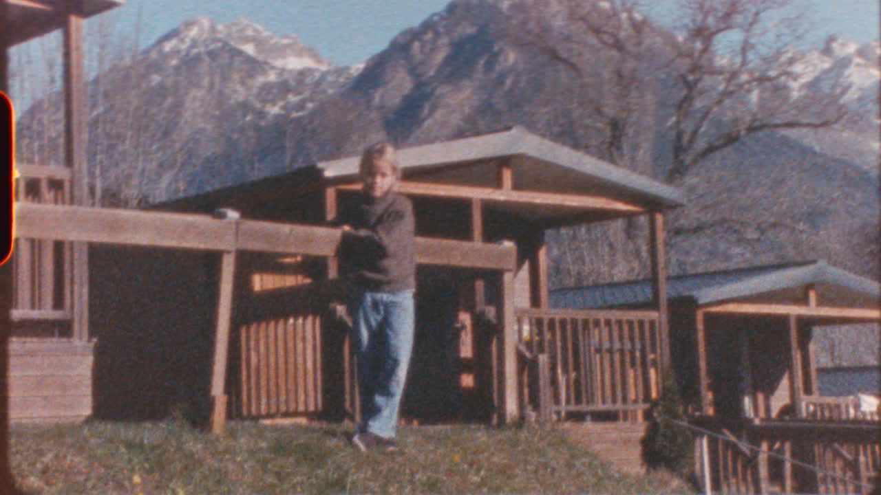 Boy standing in front of mountain cabins