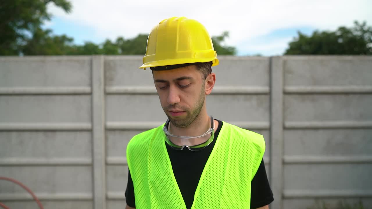 General Labourer In Yellow Helmet Signing Papers On Clipboard