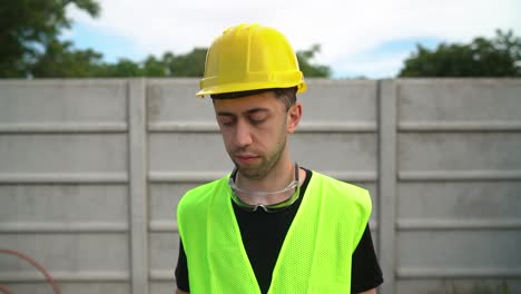 general labourer in yellow helmet signing papers on clipboard