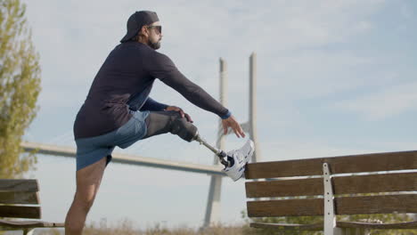 Deportista-Enfocado-Con-Pierna-Artificial-Calentando-Y-Estirando-La-Pierna-Antes-Del-Entrenamiento-Al-Aire-Libre-1